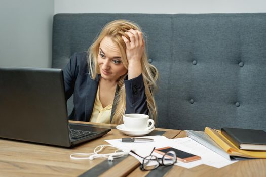 Dissatisfied surprised caucasian young woman look at laptop screen in the home office.