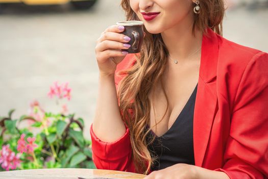 Portrait of beautiful girl having coffee at the table at cafe outdoors.