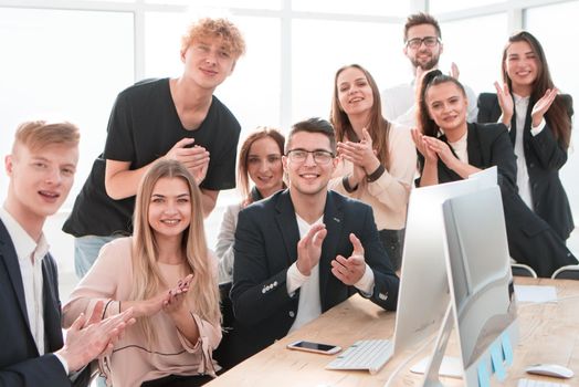 group of happy employees applauds their overall success. the concept of teamwork
