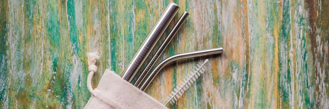 Steel drinking straws on painted wooden background. Zero waste concept. BANNER, LONG FORMAT