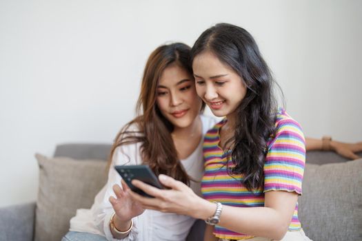 lgbtq, lgbt concept, homosexuality, portrait of two asian women enjoying together and showing love for each other while using smartphone mobile to take selfies.