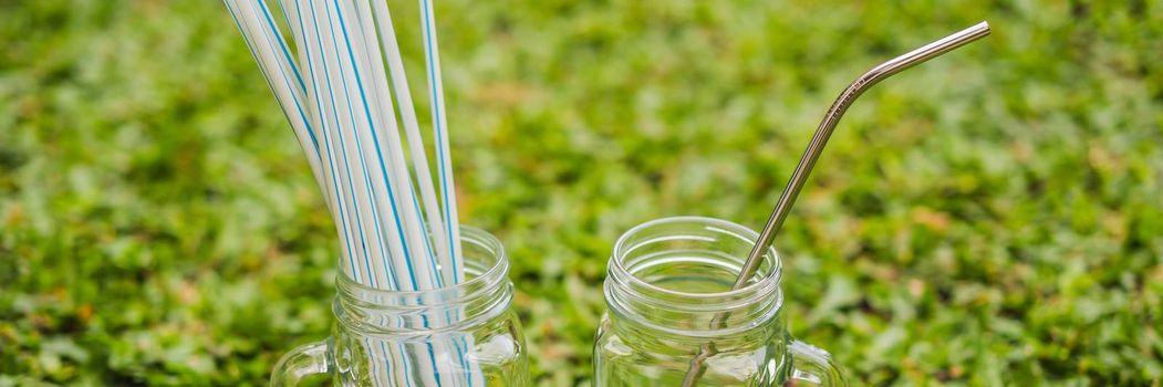 Steel drinking vs disposable straws on grass background. Zero waste concept. BANNER, LONG FORMAT