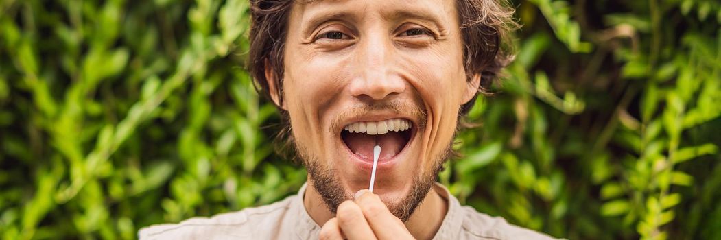 Man doing DNA test with cotton swab. Test for home use. BANNER, LONG FORMAT