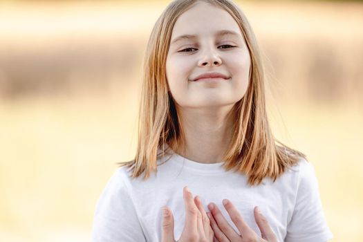 Little girl smiling in sunny spring day outdoors portrait. Cute child kid at nature