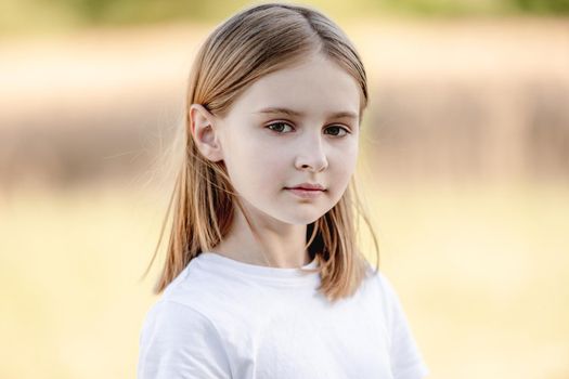 Little girl smiling in sunny spring day outdoors portrait. Cute child kid at nature