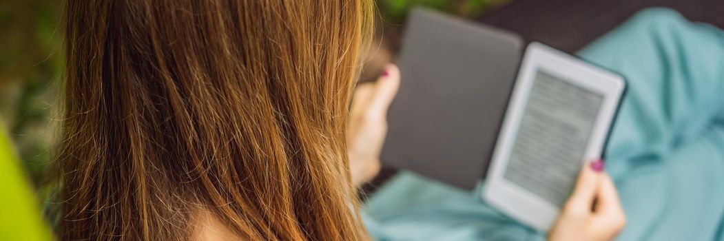 Woman reads e-book on deck chair in the garden. BANNER, LONG FORMAT