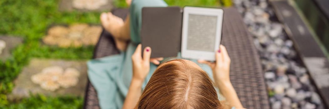 Woman reads e-book on deck chair in the garden. BANNER, LONG FORMAT