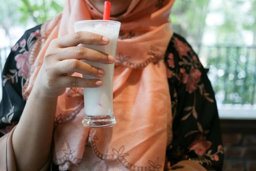young women drinking banana milk shake at cafe .
