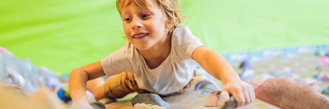 little boy climbing a rock wall in special boots. indoor. BANNER, LONG FORMAT