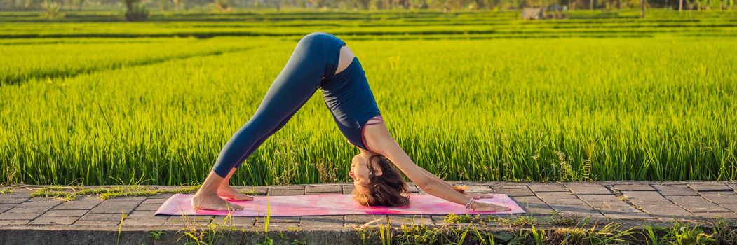 Young woman practice yoga outdoor in rice fields in the morning during wellness retreat in Bali. BANNER, LONG FORMAT