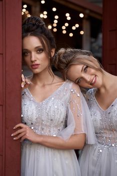 Beautiful bridesmaids in gorgeous elegant stylish silver dress decorated with sequins sparkles. Wedding day in old beautiful European city.