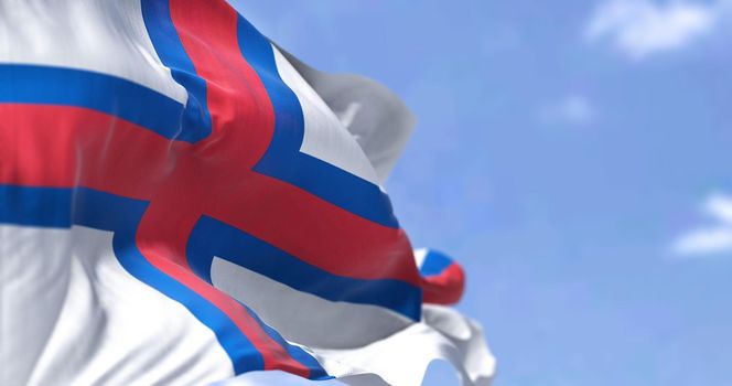 The flag of Faroe Islands waving in the wind on a clear day. Faroe Islands are a North Atlantic archipelago and island country