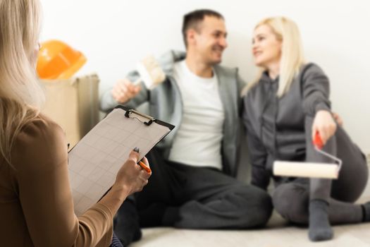 Happy young couple meeting with a broker, view from behind the female agent.