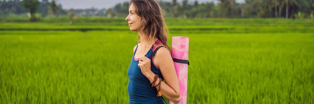 Young woman practice yoga outdoor in rice fields in the morning during wellness retreat in Bali. BANNER, LONG FORMAT