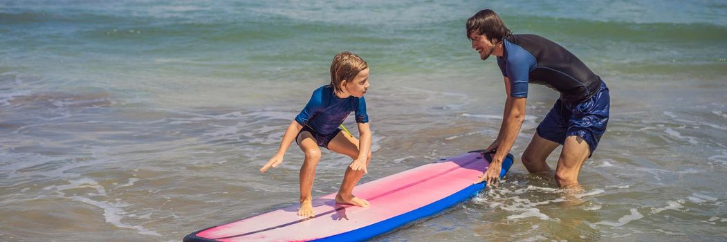 Father or instructor teaching his 5 year old son how to surf in the sea on vacation or holiday. Travel and sports with children concept. Surfing lesson for kids. BANNER, LONG FORMAT