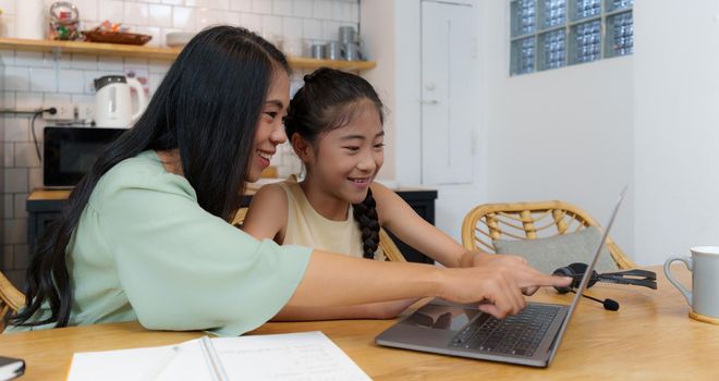 Homeschool Asian mother and little young girl student learning online class. E-learning Online Education concept
