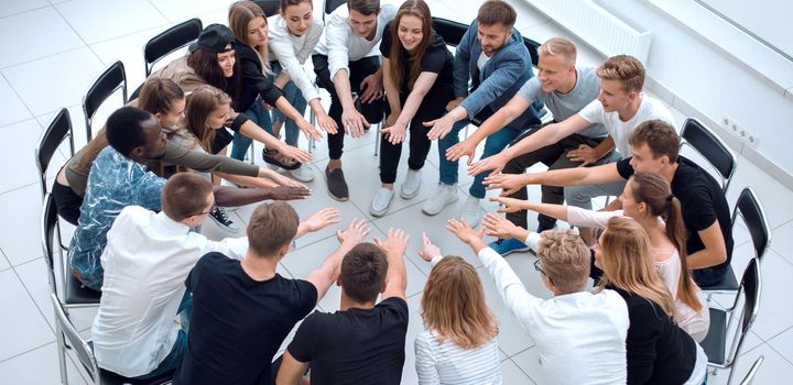 group of diverse young people putting their hands together. the concept of team building