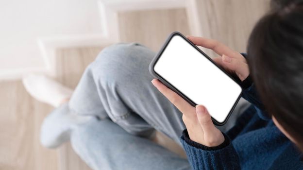 Cropped shot view of woman hands holding smart phone with blank copy space screen for your text message or information content.