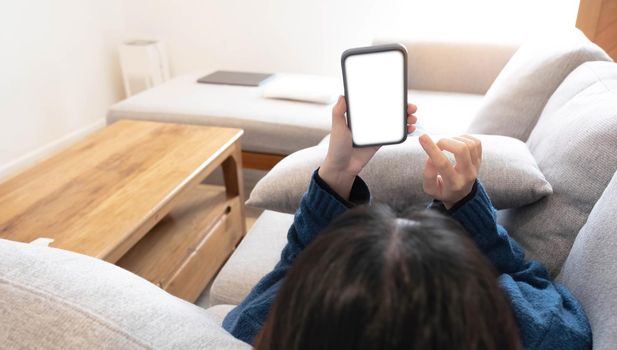 Woman configuring privacy settings on the mobile phone, lying down at home. white screen. "Privacy settings appears on the screen..