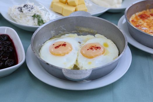 Organic, fresh traditional turkish village breakfast on wooden table with copper egg pan