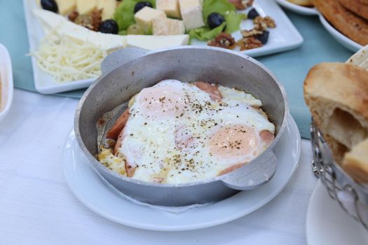 Organic, fresh traditional turkish village breakfast on wooden table with copper egg pan