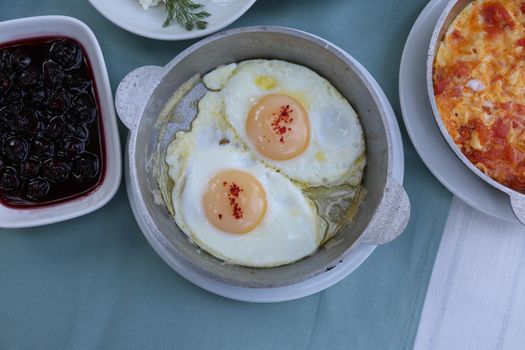 Organic, fresh traditional turkish village breakfast on wooden table with copper egg pan