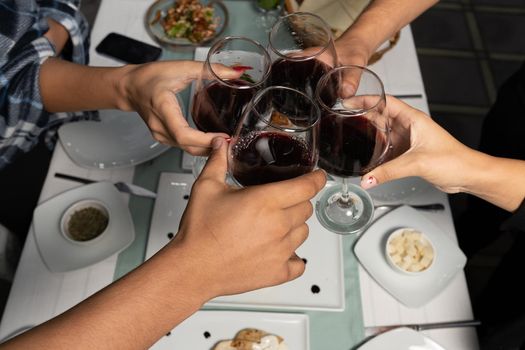 Top view shot of group of people toasting with wine glasses, Summer holiday party