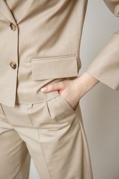 a model in a brown business suit on a studio background.