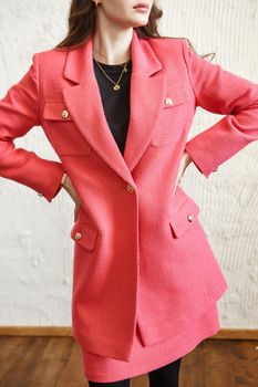 A girl model in pink clothes in the studio. Shooting fashionable clothes for the showroom.