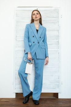 The model is a girl in a blue business suit. Shooting fashionable clothes for the store.