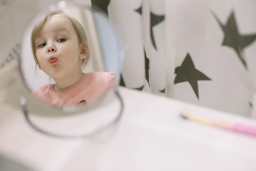 Cute toddler girl brushing teeth in the bathroom. Teeth cleaning, dental care