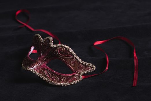 red and black mask on black background close up