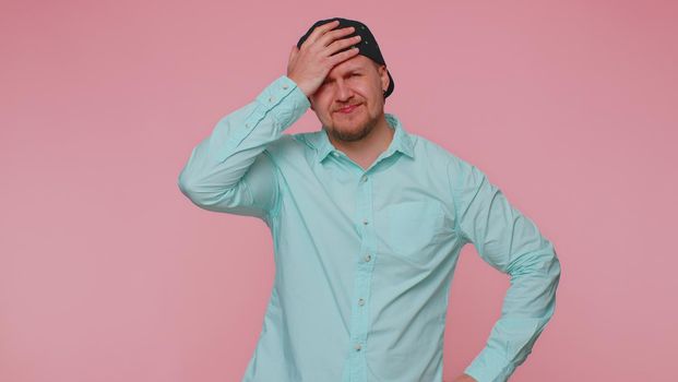 Sincere man 30s years old in blue shirt wish, waiting for good luck and loses becoming surprised sudden lottery results, bad fortune loss. Young adult guy boy isolated alone on pink background