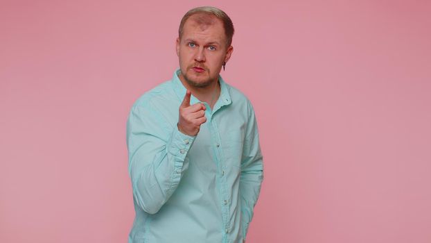 Quarrel. Displeased man gesturing hands with irritation and displeasure, blaming scolding for failure, asking why this happened. Young adult blonde guy isolated alone on pink studio wall background