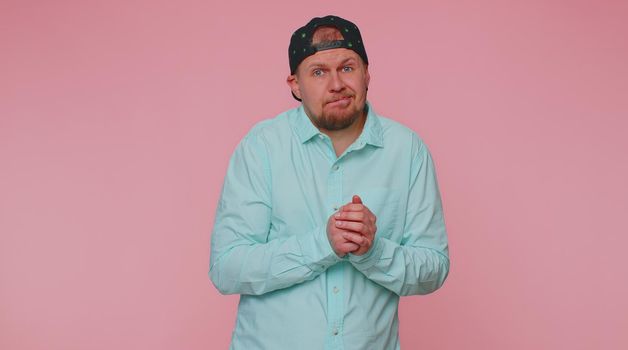 I dont know what to say. Confused man feeling embarrassed about ambiguous question, having doubts, no idea, being clueless and uncertain. Young adult guy isolated alone on pink studio wall background