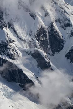 Aerial Landscape View of the mountain peak covered in clouds. Taken in remote part of British Columbia, Canada.