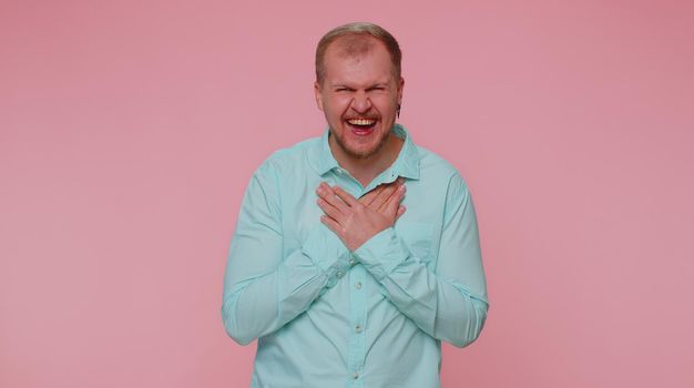 Joyful man laughing out loud after hearing ridiculous anecdote, funny joke, feeling carefree amused, positive people lifestyle. Young adult blonde guy boy isolated alone on pink studio wall background