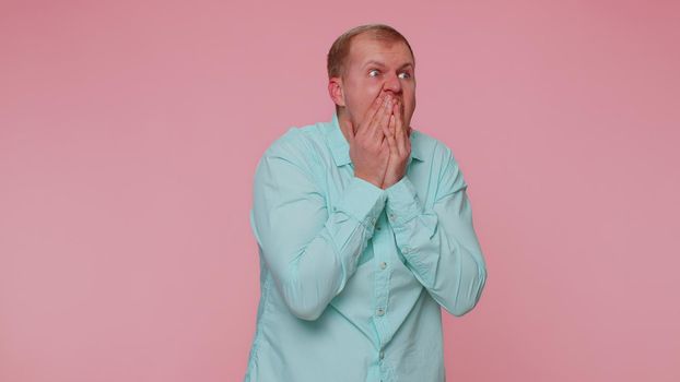Bearded adult one man scared fearful, covering ears with hands closing eyes, meeting his own phobia, evidence horror event, screaming, shouting at loud, freaked out. Young guy alone on pink background
