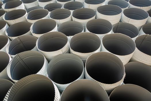 Downpipe warehouse. Steel pipes, parts for the construction of a roof drainage system in a warehouse. Stack of stainless steel pipes