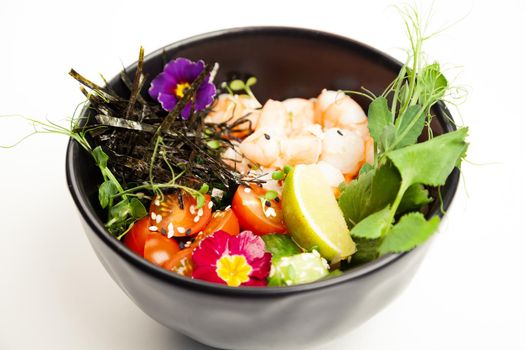 Poke salad with shrimp in a bowl. Ingredients Shrimp, blanched spinach, cherry tomatoes, rice, cucumber, soy-ginger sauce, Spicy sauce, nori, sesame, lime, cilantro. Asian seafood salad concept