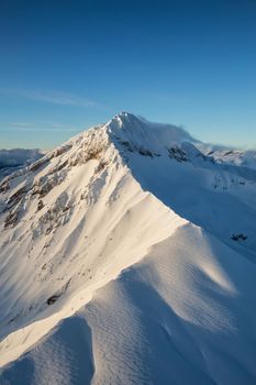 Aerial landscape view of Garibaldi Mountain near Squamish, British Columbia, Canada, during a winter sunset.
