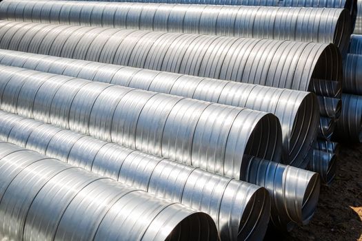 Ventilation pipe warehouse. Steel pipes, parts for the construction of air ducts for an industrial air conditioning system in a warehouse. Industrial airway ventilation equipment and piping systems.