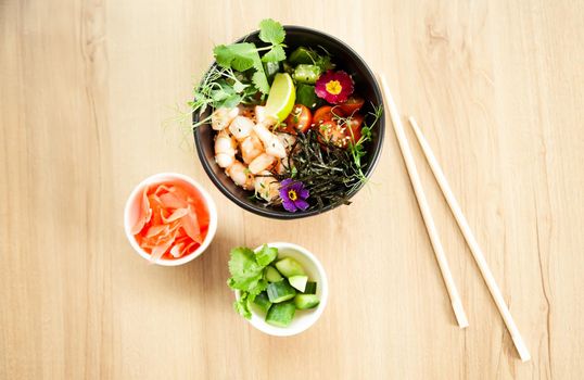 Poke salad with shrimp in a bowl. Ingredients Shrimp, blanched spinach, cherry tomatoes, rice, cucumber, soy-ginger sauce, Spicy sauce, nori, sesame, lime, cilantro. Asian seafood salad concept