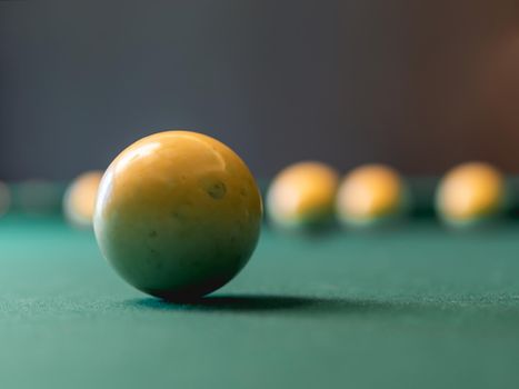 Close up photo of billiard balls on green pool table.