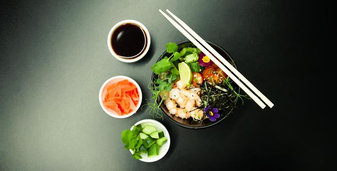 Poke salad with shrimp in a bowl. Ingredients Shrimp, blanched spinach, cherry tomatoes, rice, cucumber, soy-ginger sauce, Spicy sauce, nori, sesame, lime, cilantro. Asian seafood salad concept