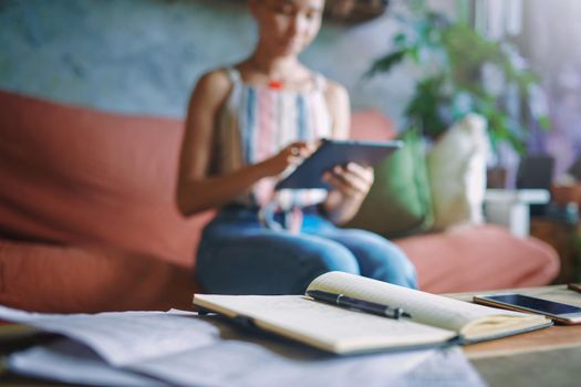 Still shot of notebook on coffee table with person in background. High quality photo