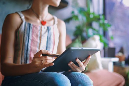 Cropped Shot of a beautiful African woman doing online banking from her sofa