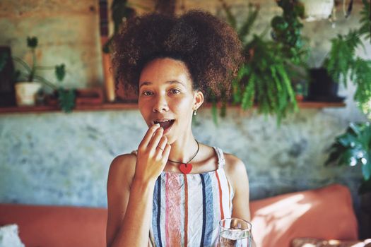 Shot of a beautiful African woman drinking medication in her living room - Stock Photo