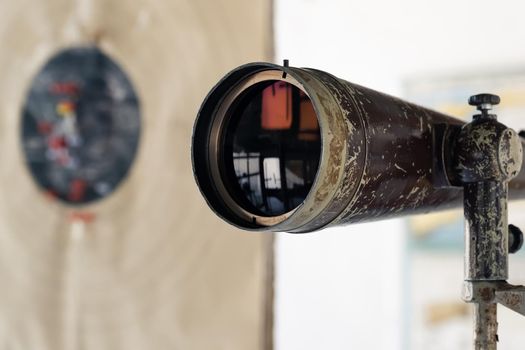 Spyglass in the shooting range to watch the target hit. The shooting range instructor looks at the target through a telescope. Optical tube for monitoring and monitoring training in the shooting range