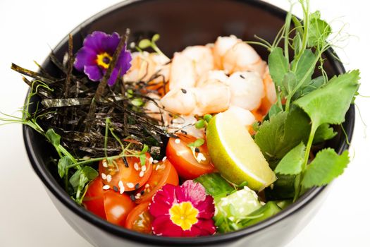 Poke salad with shrimp in a bowl. Ingredients Shrimp, blanched spinach, cherry tomatoes, rice, cucumber, soy-ginger sauce, Spicy sauce, nori, sesame, lime, cilantro. Asian seafood salad concept
